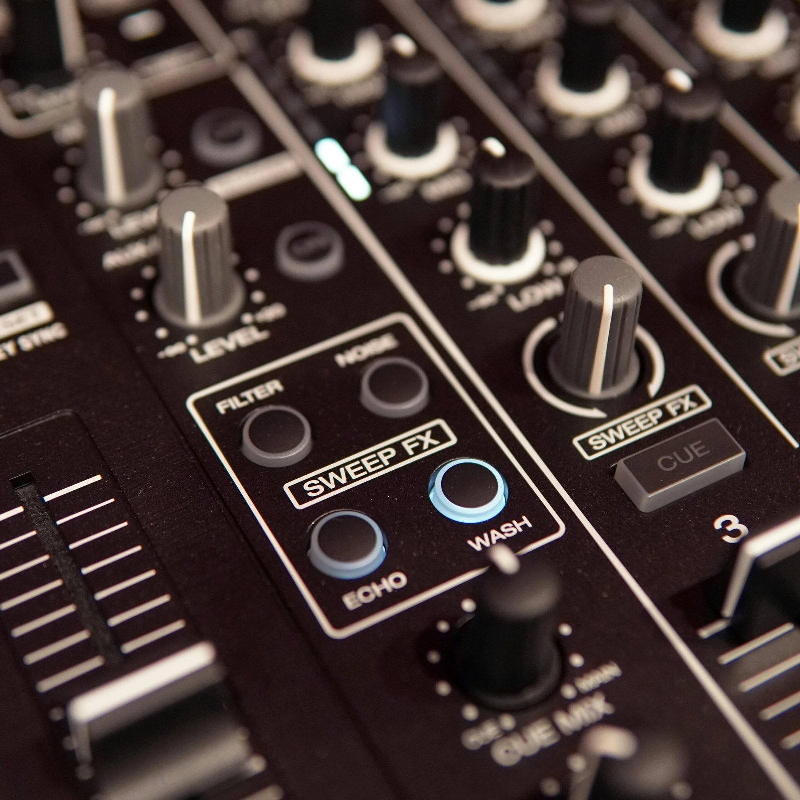 Detailed photo of an audio mixing console showing various control knobs and buttons.